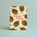 A vertical greeting card featuring a repeating fish pattern of cartoonish flounders on a sandy cream background, with the red text 'You've never floundered.' in the center, depicted against a light blue wall and surface.